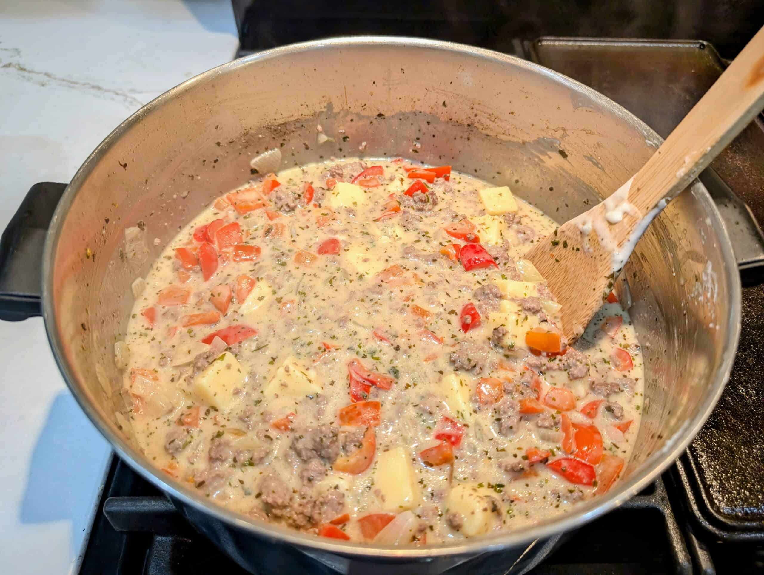 Sharp cheddar cheese added to Philly Cheeseburger Soup 